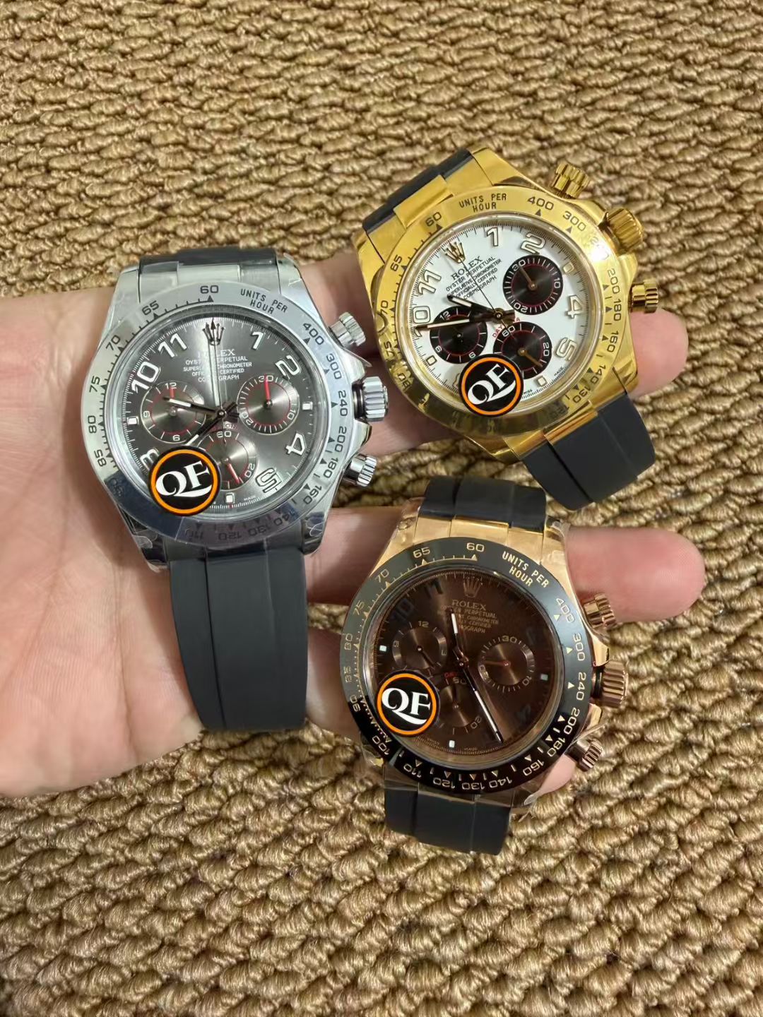 Three Daytona-style Rolex replica watches in different case materials photographed side by side